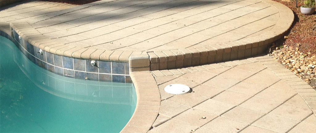 A photo of sealed pavers before the application is applied to the faded pavers