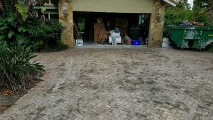 Pressure washing a Boca Raton driveway, & then restoring the faded pavers to a like new condition by National Sealing Company